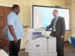 Canadian High Commissioner Charles Court (right) hands over the photocopier to GPSU President Patrick Yarde. 