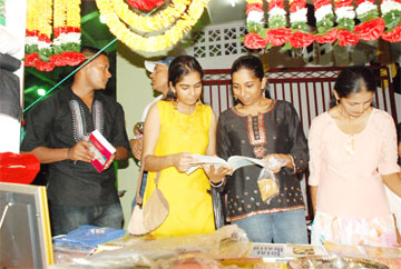 Patrons examining the religious books that were available at the  Bhajan Deepanjali on Wednesday night at the National Stadium, Providence.