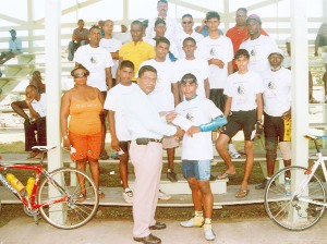 Regional Chairman of Region 6 Zulfikar Mustapha hands over the first prize to race winner Neil Reece at the completion of the race. Other prize winners are in the background. (Calvin Roberts)