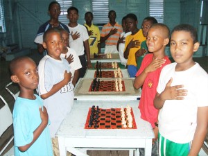 Primary and secondary school students representing a sprinkling of schools from Georgetown, the East Coast and East Bank of Demerara, proudly recite the national pledge before beginning a chess instruction class at the Malteenoes Sports Club on Wednesday. Malteenoes President Lance Hinds in association with the Guyana Chess Federation launched chess classes recently at the club for youths wishing to play the game. Young people are free to join the chess classes at Malteenoes and can contact Mr Hinds for further information.