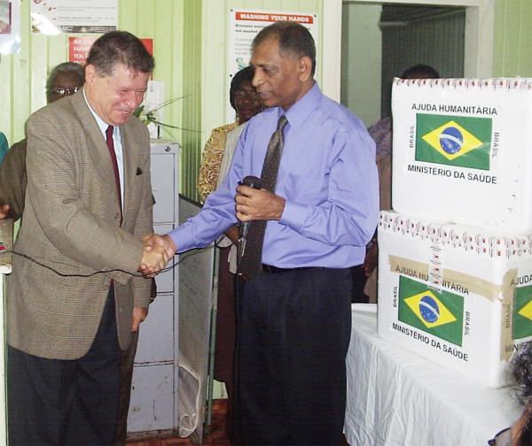 Minister of Health Dr Leslie Ramsammy thanks Brazilian Ambassador Arthur Meyer. The vaccines are at right. 