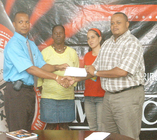 Local Manager of Ansa McAL Troy Cadogan (extreme right) hands over the cheque to ECDFA President Aubrey Hutson with Secretary Sheron Abrams (2nd left) and Ansa McAL Marketing Assistant Anjeta Hinds (second left) looking on. (Aubrey Crawford photo)  
