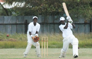 Herrell Greene executes a shot off the front foot as wicket-keeper Dexter Solomon pays close attention in the Essequibo/Demerara under-17 Guyana Cricket Board/Clico sponsored match at Enterprise Community Centre ground yesterday. (An Aubrey Crawford photo).   