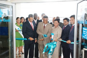 The official opening:  Republic Bank (Guyana)’s new  signature branch  at Camp Street was officially opened  yesterday. President Bharrat Jagdeo unveiled the commemorative plaque earlier in the day and Prime Minister Samuel Hinds is photographed here cutting the ribbon  in the presence of officials and staff. In the front row from left are Managing Director Edwin Gooding, PM Hinds, Mrs Yvonne Hinds, Finance Minister  Dr Ashni Singh and Chairman of the Board of Directors David Dulal-Whiteway. (Photo  by Jules Gibson)