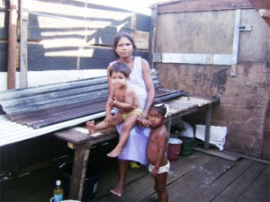 Ovena Braithwaithe with her children, Keith and Linda Mariano inside the little one-room building they lived in before a storm blew the roof off.   