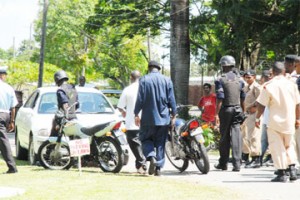 Police ranks at the Botanic Gardens yesterday examining the thief’s car minutes after his getaway was thwarted. (Photo by Clairmonte Marcus)  