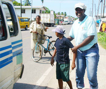 A child who was sent on an errand is picked up by staff of the education department. One officer holds him while the other takes charge of the bicycle he was riding. (Shabna Ullah photo)