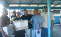 AFC’s General Secretary, Clayton Hall (second from right) hands over some of the items to chairperson of the Santa Rosa Primary School PTA, Mark Atkinson while AFC leader, Raphael Trotman (right) looks on with other parents. (AFC photo)