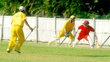 Berbice middle-order batsman Homchand Pooran is beaten and bowled by Andrew Wong as wicketkeeper Wayne Osbourne and fielder Norman Fredericks, backing camaera rejoice. (Lawrence Fanfair photo)