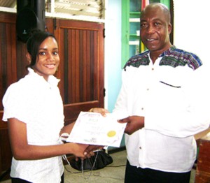 Susan Hamilton, Region Ten’s top CSEC performer receives her certificate and bursary from Personnel and Industrial Relations Superintendent of Linmine Secretariat, Peter Benny.
