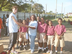 German sports scientist Uwe Wenzel (L) congratulates the winning team, Red Lions at the conclusion of the Kids Athletics Championships which was held at the All Saints Primary School ground in New Amsterdam, Berbice.