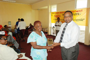Joan Baveghems receiving an award yesterday from PNCR Leader Robert Corbin in commemoration of senior citizens’ month. Several others were also handed awards. 