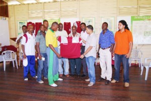  Middle St. Plaza Managing Director Salim Paul hands over the new DCC uniforms to club player Christopher Barnwell in the company of DCC officials (Lawrence Fanfair photo)