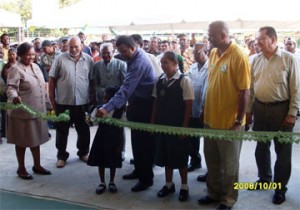 Minister of Agriculture, Robert Persaud (fourth from right) and a Parika student cutting the ribbon at the formal opening of the Parika Agro and Export Facility yesterday. 