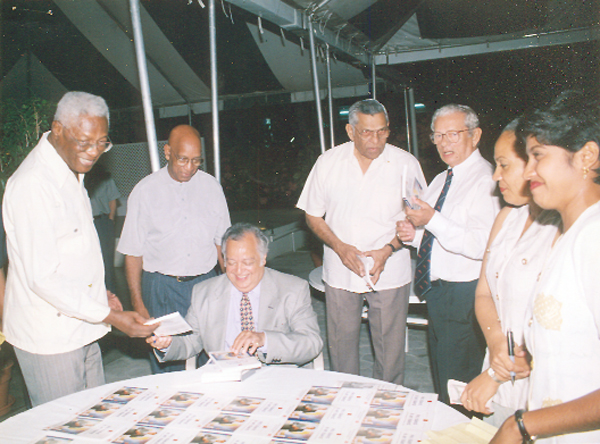 Sir Shridath hands Leader of the Opposition Desmond Hoyte a copy of his book, No Island is an Island, 2000 (Stabroek News file photo)