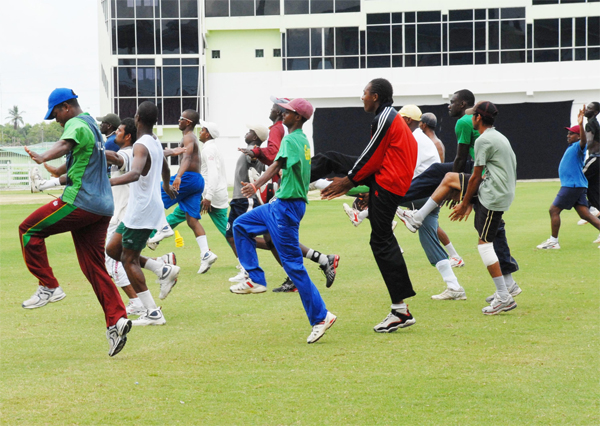 Skipper Leon Johnson (left) leads his team during their warm up exercises at the Guyana National Stadium, Providence yesterday.  