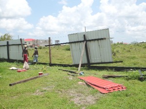 Workers yesterday at Funtime Day Care, Diamond Housing Scheme as they were repairing the back fence damaged by the storm on Friday.