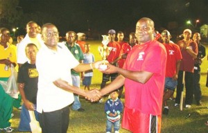  Banks DIH Captain Owen Grannum (right) receives the winning trophy from Governor of Bank of Guyana Lawrence Williams.    