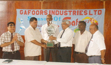 President of the Guyana Cricket Board (GCB) Chetram Singh (2nd left) receives the championship trophy from Chief Executive Officer of Gafsons Industries Limited Mohammed Ali (3rd right) while other executives of both the GCB and Gafoors look on. (Aubrey Crawford photograph) 