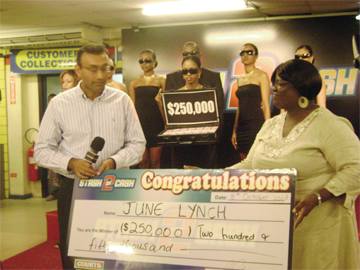 Country Manager of Courts, Lester Alvis (left) presenting June Lynch with her cash prize yesterday.