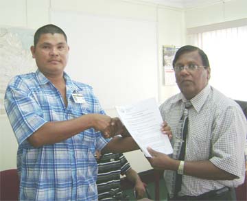 Kwebana Village Toshao Troy Peters, left, and EPA Executive Director Doorga Persaud after signing the $6.8M agreement last month. 