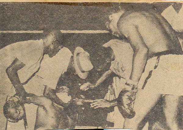 Officials in the ring tend to the fallen Henry Brown while his opponent Linton John at right looks on with concern.  
