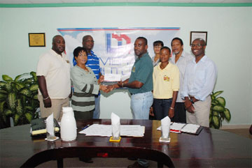 Demerara Mutual Life Public Relations Manager Marjorie Chester hands over a cheque to GRFU Senior Vice President Robin Peters while GRFU and Demerara Mutual members look on. (Clairmonte Marcus photo)  