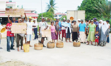 Cotton Tree residents, fed up after having been without potable water for two weeks, protesting on the street yesterday. The residents held placards and used empty buckets and baskets to demonstrate their point. (Photo by Shabna Ullah) 