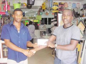 Marketing Representative of 2J’s General Store Leon Edwards (L) presents a cheque to president of the Fruta Conquerors FC, Marlan Cole which  will be presented to the MVP of the Namilco Football Festival Tournament. 