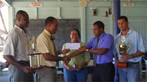 Malteenoes vice president Neil Barry,extreme left looks on as Ansa McAl’s  Nigel Worrell hands over the cheque for $130,000 to Arron Fraser, second from left while Theresa Pemberton, centre  Sean Devers look on. (Lawrence Fanfair photo)  