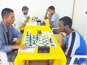 Haatram Parbat faces Brian Thompson in the just concluded qualification chess tournament for entry into the National Championships. In the background Omar Sharif and Robert Arjoon ponder their moves. 