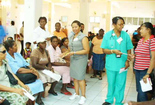  Nurses Dawn Zimmerman (left) and Mavis Charles distributing pamphlets to patients at the New Amsterdam Hospital as they await their turn to be treated.
