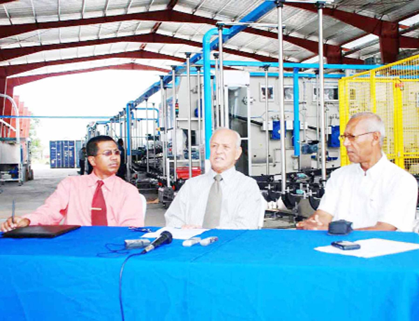 DDL Chairman Dr Yesu Persaud is flanked by, left, General Manager Loris Nathoo and board member Bert Carter.   