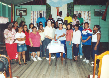 Stabroek News Editor in Chief and Chairman of the Board of Directors David de Caires and his wife Doreen de Caires (centre) cut the cake in the presence of staff at this newspaper’s 20th anniversary celebration in November 2006. (Stabroek News file photo) 