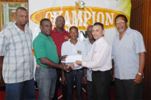 Area Manager of Edward B. Beharry Group of Companies Harry Shewpaltan (right) hands over the cheque to manager of the Guyana Rugby Football  Union (GRFU) teams Robin Roberts (second left) as other executives of the GRFU look on appreciably. (Photograph by Clairmonte Marcus)                                            