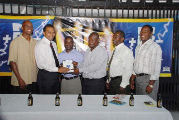 Minister of Sport Dr. Frank Anthony (second left) and Banks DIH Public Relations Manager Troy Peters (third right) award Guyana’s bodybuilding star Sylvan Gardner (third left) at the Banks DIH Sports Club while GABBFF’s president Frank Tucker (second right), former president George Marshall (left) and secretary Franklin Wilson look on. (Clairmonte Marcus photo)    