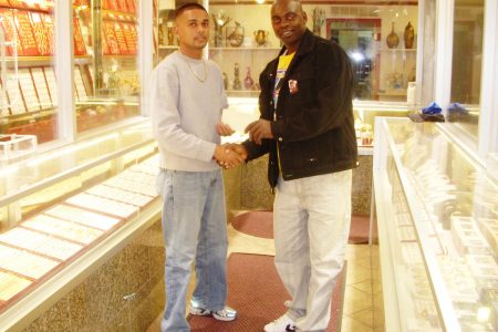 Managing Director of Robin’s Jewel Shop, Robin Persaud (L) hands over a sponsorship cheque to Director of the Kashif & Shanghai Organization  Aubrey Major (R) in Robin’s Jewel Shop, Brooklyn, NY recently.