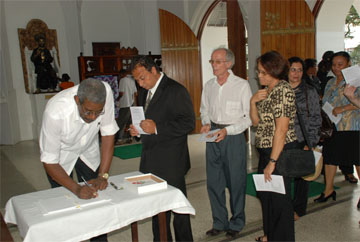 The book of condolence being signed by Hugh Cholmondeley for Stabroek News Editor-in-Chief David de Caires at yesterday’s memorial service.