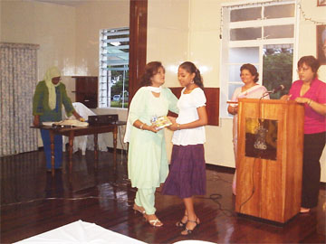 One of the Impromptu Speech competition winners, Sudha Joshi (right), receiving her prize at the Indian Cultural Centre Education Day celebration on Tuesday.
