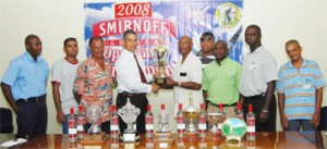 Banks DIH Sales and Marketing executive Carlton Joao, hands over the trophies for the 2008 Smirnoff Guyana Open golf tournament to Mel Sankies yesterday at Banks DIH Thirst Park. (Lawrence Fanfair photo)   