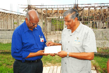 Veterans Rest Home closer: CEO of GT&T Major General (rtd) Joe Singh (right) presenting a cheque to Chairman of the Guyana Veterans Foundation Col (rtd) Carl Morgan on Thursday on behalf of GT&T at the Essequibo Street, Lamaha Springs site of the rest home. (Photo by Jules Gibson)