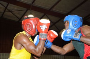 Guyana Defence Force’s (GDF) Bert Braithwaite squeezes an uppercut through Republican Gym’s Damien Ross’s defence in their light welterweight bout on the first night of the Church’s Chicken Champion of Champions tournament at the National Gymnasium. (Clairmonte Marcus photo)     
