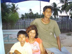 A mournful Sabita Rampersaud and her two remaining children, Tony (right) and Keon (left). 