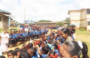 Schoolchildren eagerly wait to greet Prime Minister Samuel Hinds, who visited the North West District community of Port Kaituma yesterday.  