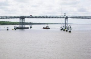 A tug crosses under the high span of the Berbice River Bridge yesterday.  