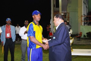 Dwayne Smith returned to form with the bat and was subsequently voted the best batsman of the tournament. Above he receives his prize from Guyana Cricket Board president Chetram Singh, right. 