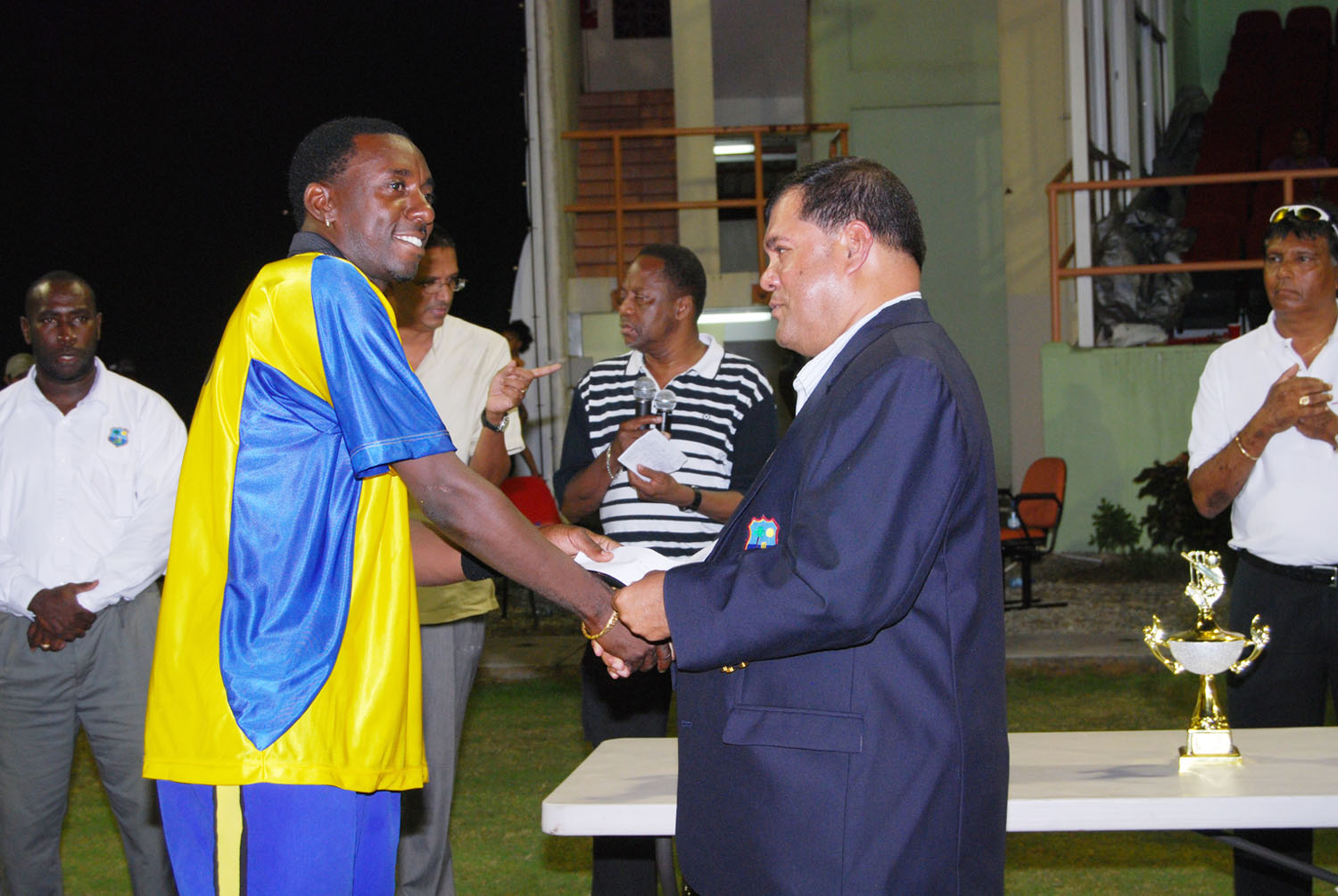 Pedro Collins, left receives his bowler of the series prize from Guyana Cricket Board president Chetram Singh.