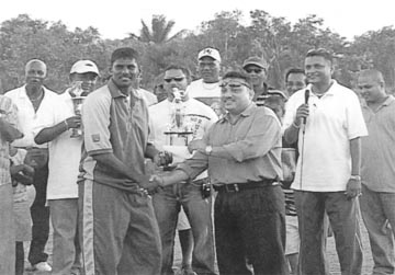 Best Bowler and Man-of-the-match Mahendra Nagamootoo receiving his trophy from president of the Demerara Cricket Board (DCC) Bissoondyal Singh as New Line Aqua Farm Proprietor Salim Azeez, centre, watches on.