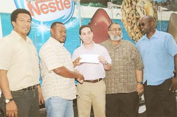 Finance Officer of the Kashif and Shanghai Organization Troy Mendonca (second left) receives the sponsorship cheque from Nestle’s Caribbean Business Representative Ilias Munoz while CEO of Bakewell Naeem Nasir (second right) and Director and Co-Director of the K&S organization Aubrey ‘Shanghai’ Major (right) and Kashif Mohammed (left) look on. (Clairmonte Marcus photo)