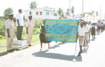 Traffic Chief, Owen Trotz (left), Assistant Traffic Chief, Brian Mc Kenzie and vice-chairman KP Deokarran(centre) taking the salute as the students marched during the rally. 